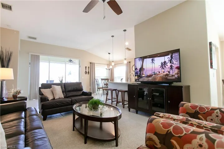 Living room featuring ceiling fan and lofted ceiling