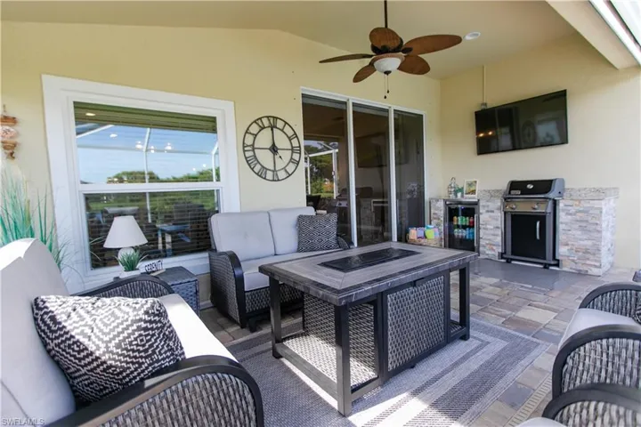 Deck with ceiling fan, an outdoor living space, a patio, area for grilling, and exterior kitchen