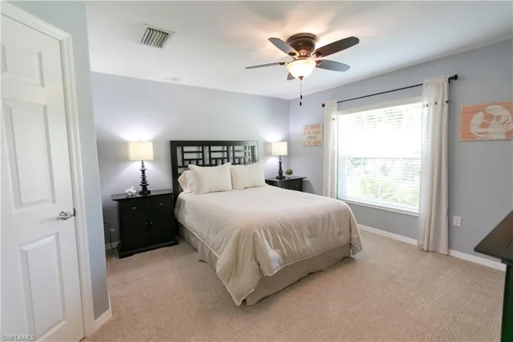 Carpeted bedroom featuring ceiling fan