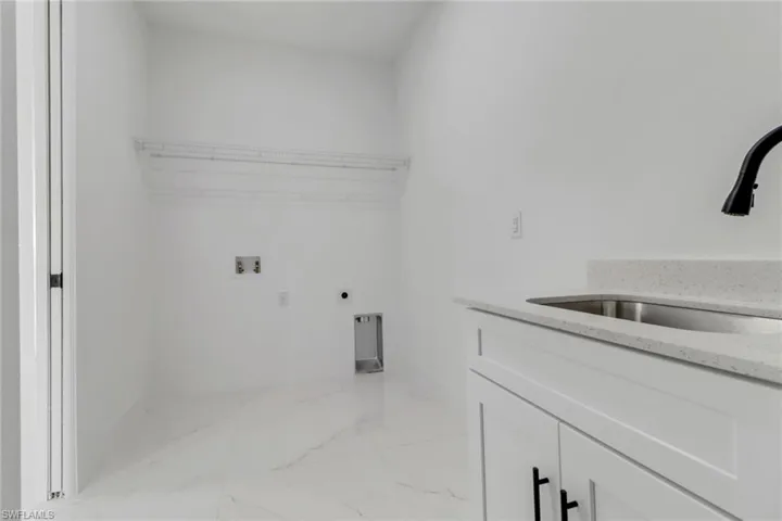 Laundry room featuring cabinets, washer hookup, electric dryer hookup, and sink