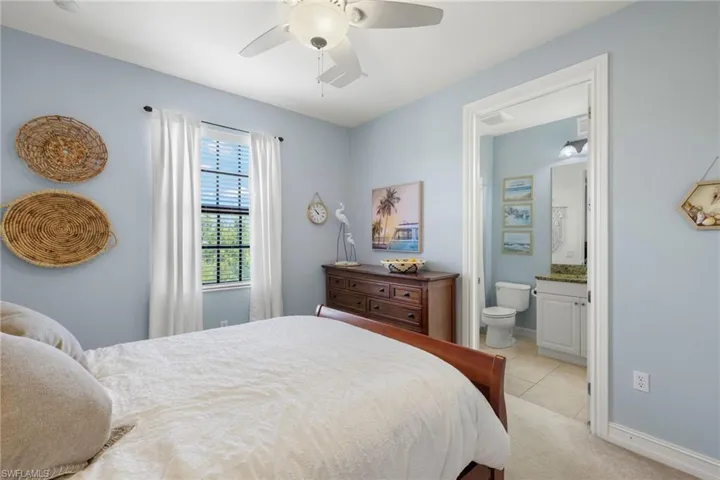 Tiled bedroom with ensuite bathroom and ceiling fan