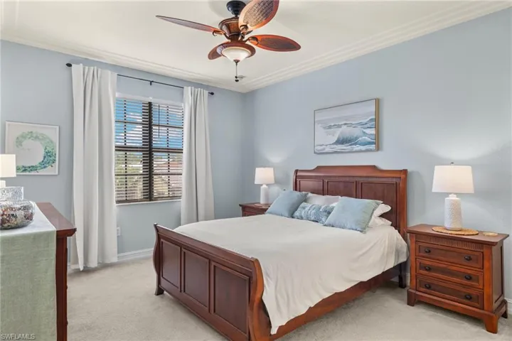 Bedroom featuring light carpet, crown molding, and ceiling fan