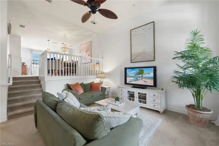 Living room with light colored carpet and ceiling fan