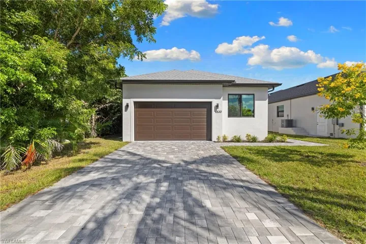 Contemporary exterior with a wide paver driveway, an integrated garage, and a modern window