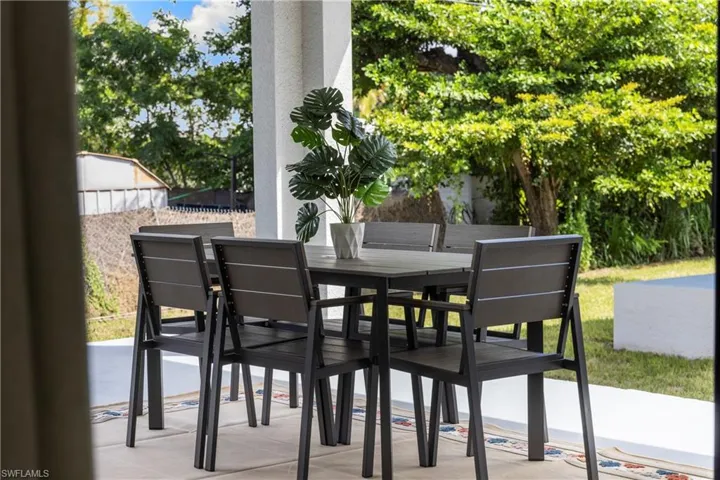 Covered patio featuring a concrete floor, structural columns, and a decorative area rug