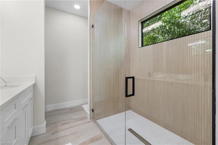 Contemporary bathroom featuring a spacious glass-enclosed shower with a linear drain