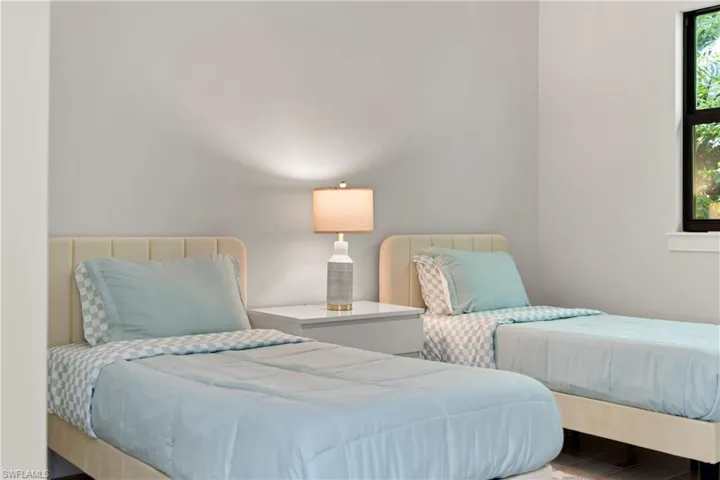 Room featuring light gray walls, a black-framed window, and wood-finish flooring