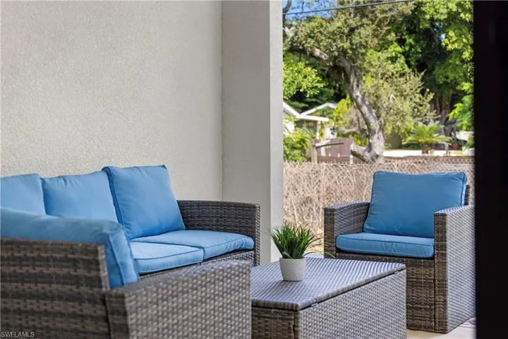 Shaded patio area with textured exterior wall and a natural wood fence