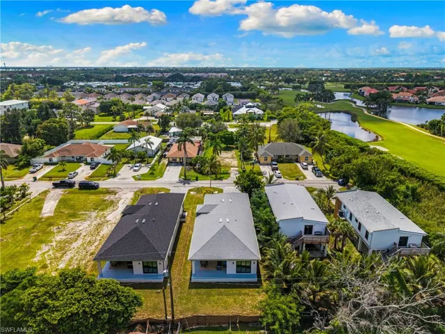 Aerial perspective showcasing multiple properties within a developed community, featuring both established residences and new construction