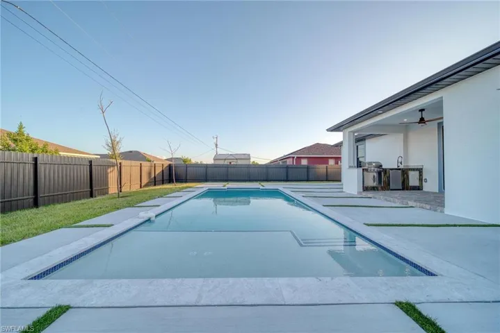 View of swimming pool featuring a patio area and an outdoor kitchen