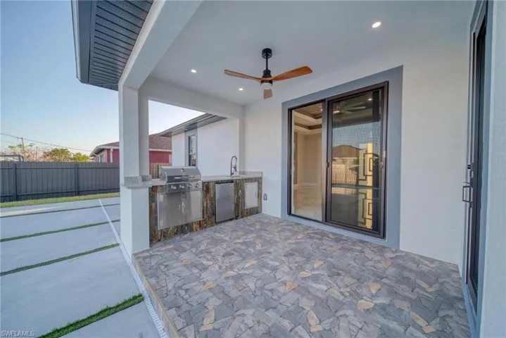 View of patio / terrace with area for grilling, sink, and ceiling fan