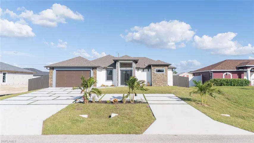 View of front of home featuring a front lawn and a garage