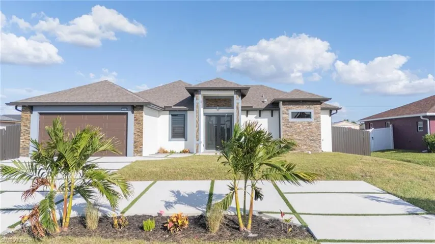 View of front facade featuring a front lawn and a garage