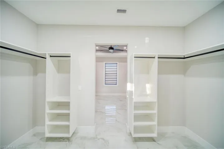 Walk in closet with ceiling fan