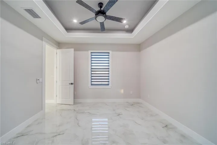 Spare room featuring a tray ceiling and ceiling fan