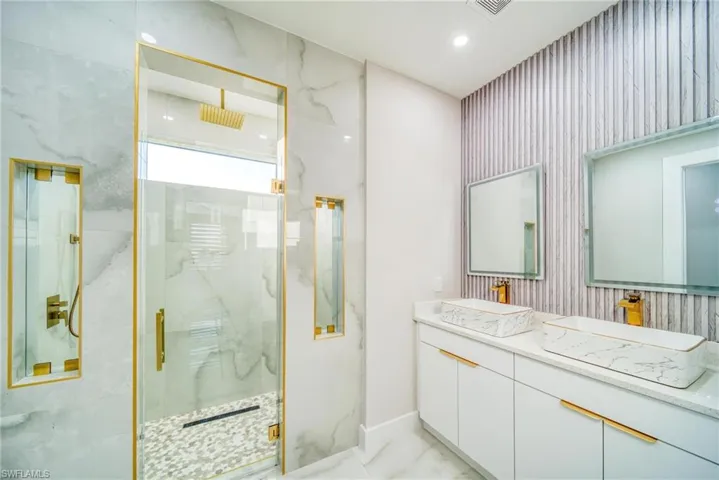 Bathroom featuring vanity and a shower with door