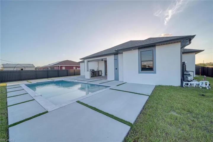 Pool at dusk featuring a yard and a patio area