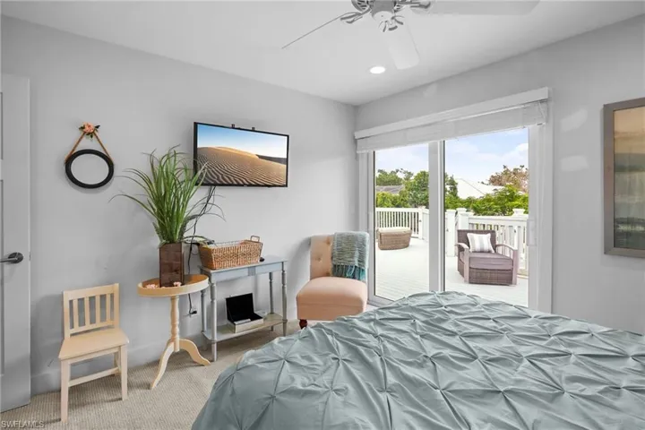 Bedroom with access to exterior, carpet flooring, and ceiling fan