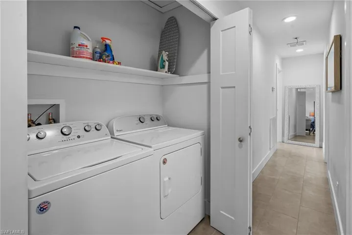 Laundry area with separate washer and dryer, recessed lighting, and light tile patterned floors
