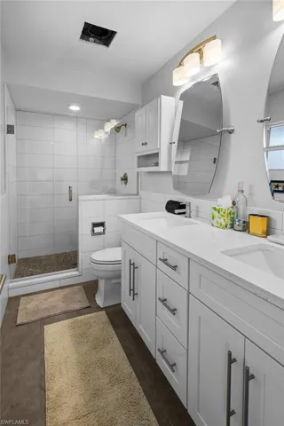 Bathroom featuring double vanity and a shower stall