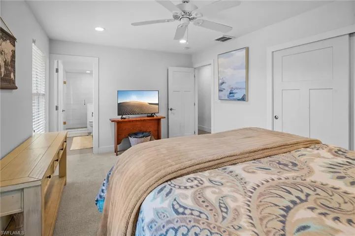 Bedroom with light carpet, a ceiling fan, recessed lighting, a closet, and connected bathroom