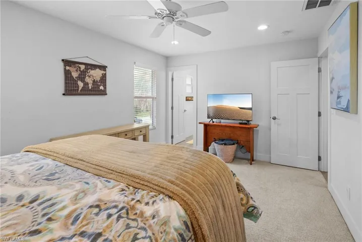 Bedroom with light colored carpet, a ceiling fan, and recessed lighting