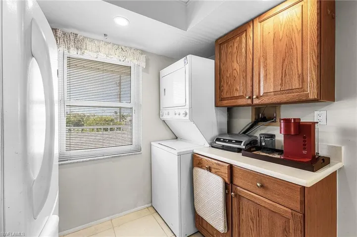Kitchen with tile flooe, stacked washer and clothes dryer, and cabinet space