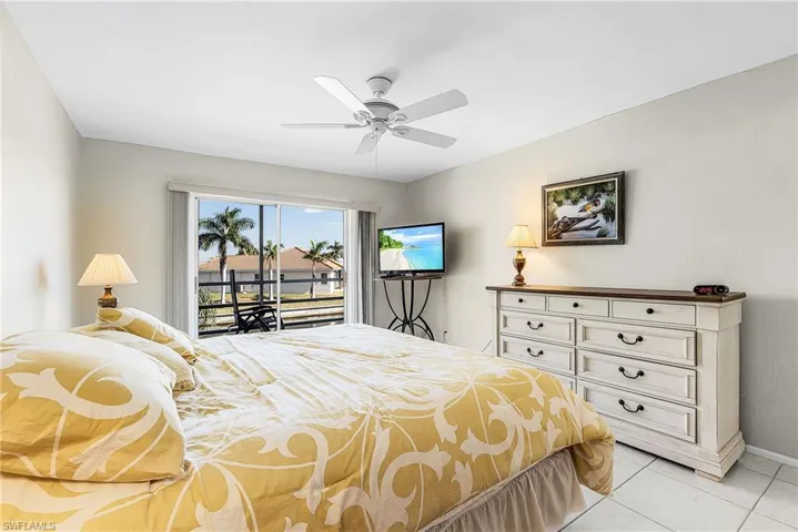 Bedroom featuring access to outside, ceiling fan, and light tile patterned flooring