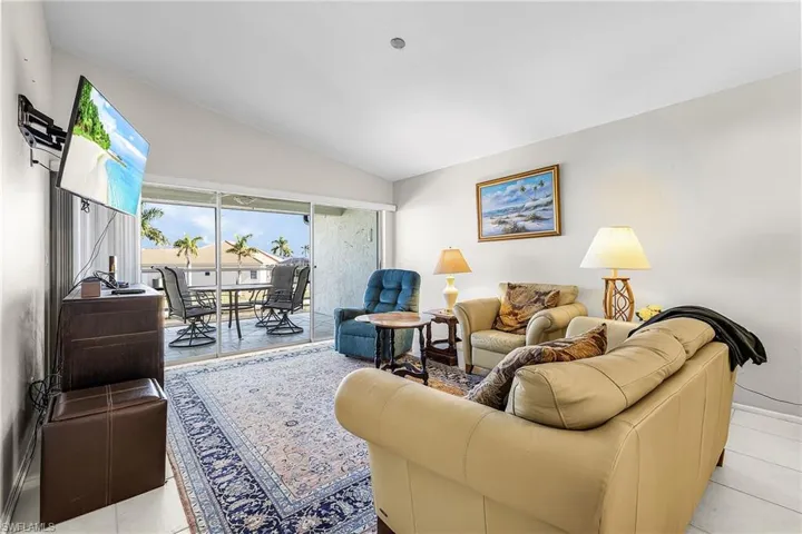 Living area with light tile floors and vaulted ceiling