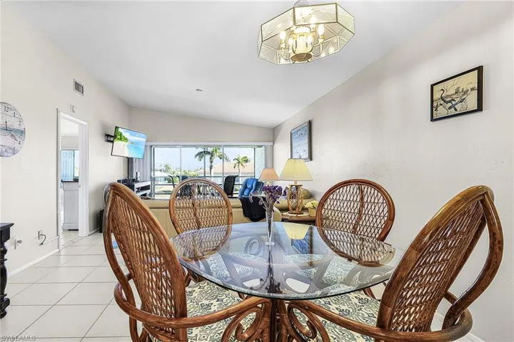Tiled dining room with vaulted ceiling and a chandelier