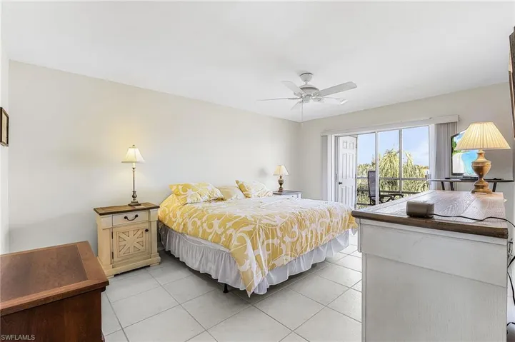 Bedroom with light tile patterned flooring, access to outside, and ceiling fan