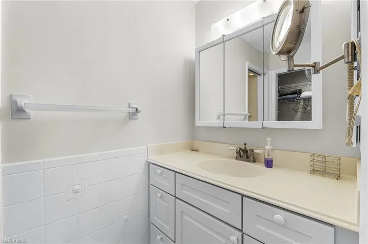 Bathroom with tile walls, vanity, and wainscoting