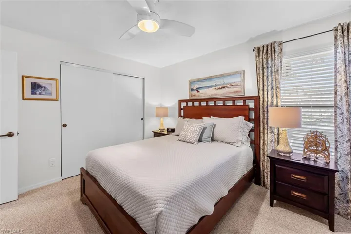 Bedroom featuring a closet, light carpet, and ceiling fan