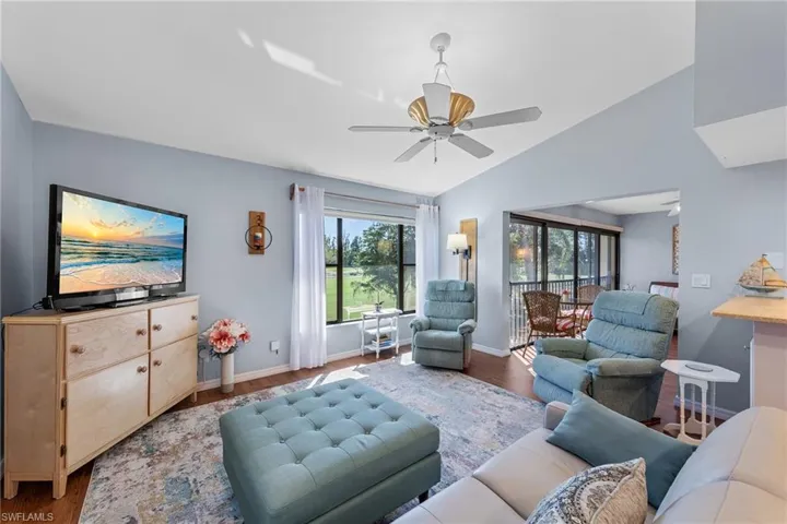 Living room featuring vaulted ceiling, wood finished floors, and ceiling fan
