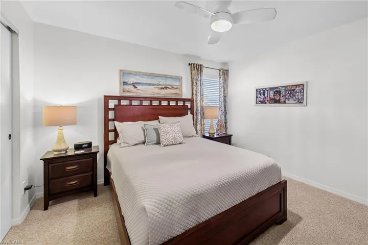 Bedroom with light carpet and a ceiling fan