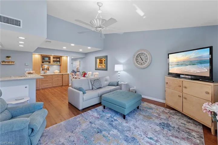 Living area with light wood-style flooring, vaulted ceiling, a ceiling fan, and recessed lighting