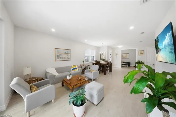 Living area with light wood finished floors and recessed lighting