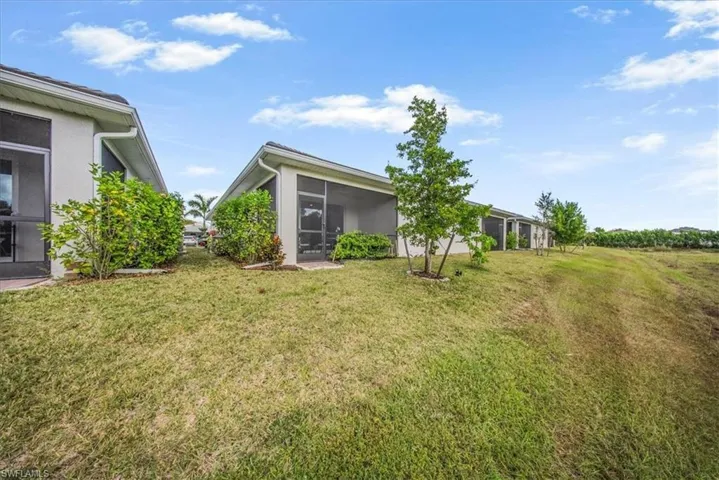 View of green lawn featuring a sunroom