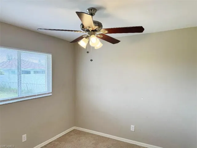 Carpeted empty room with ceiling fan