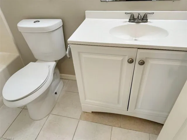 Full bathroom featuring tub / shower combination, tile flooring, toilet, and vanity