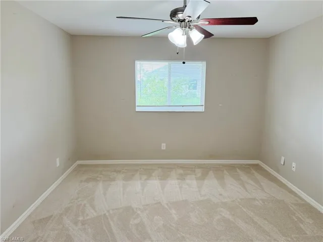 Empty room featuring carpet flooring and ceiling fan
