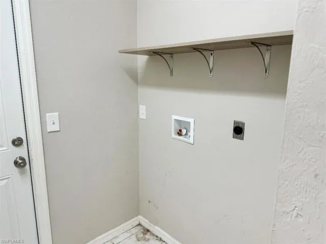 Clothes washing area featuring hookup for a washing machine and hookup for an electric dryer