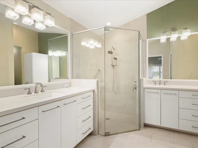 Bathroom featuring walk in shower, tile patterned floors, and vanity