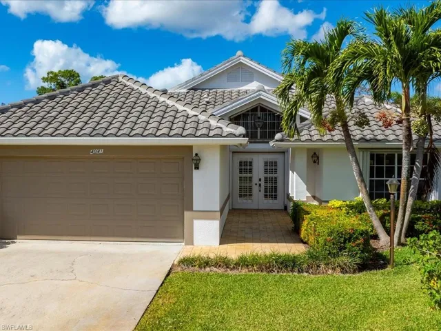 View of front of house with a garage, a front yard, and french doors