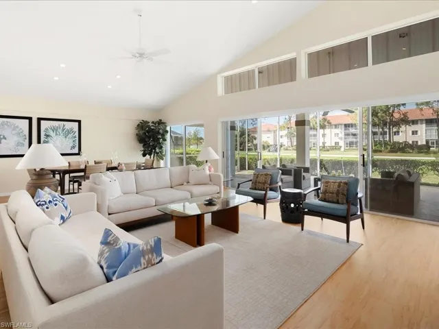 Living room featuring high vaulted ceiling, light hardwood / wood-style floors, and ceiling fan
