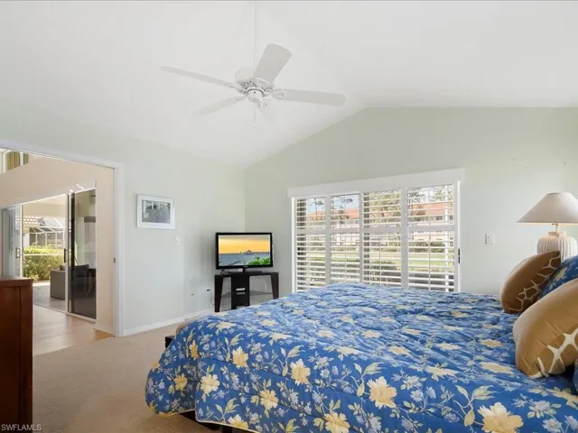 Bedroom featuring vaulted ceiling, carpet flooring, and ceiling fan