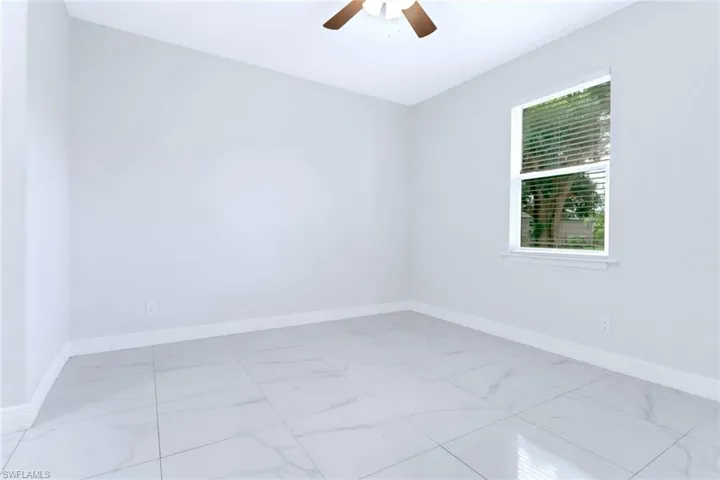 Empty room with baseboards and a ceiling fan