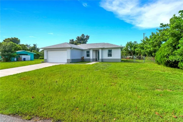 Single story home featuring concrete driveway, stucco siding, and a garage