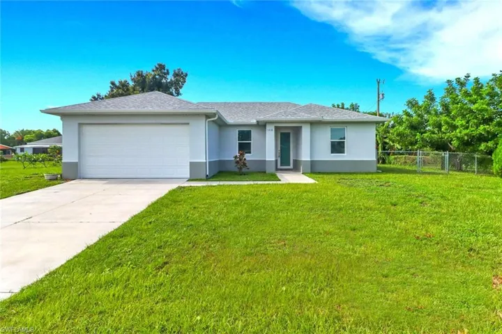 Ranch-style house with concrete driveway, stucco siding, an attached garage, and roof with shingles