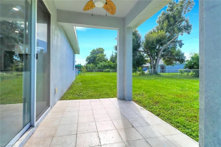 Fenced backyard featuring a patio and ceiling fan